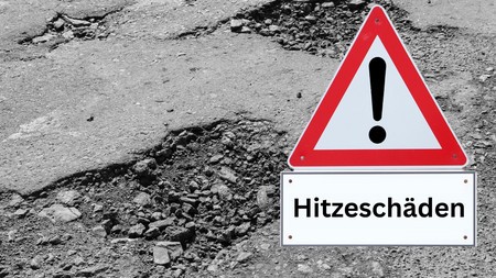 Schild "Hitzeschäden" vor kaputter Straße