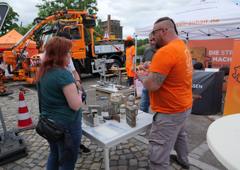 Frau am Stand der Bohrkerne und Baustoffe für Straßen