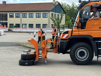 Schneepflug verschiebt einen Reifenstapel in ein vorgegebenes Feld
