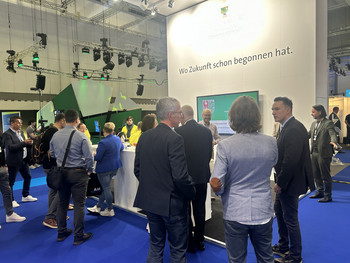 Vor dem Messestand des Ministeriums für Infrastruktur und Digitales stehen Besucherinnen und Besucher