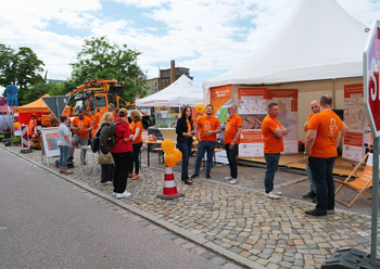 Blick über den Stand der LSBB: Zelt und Personal sowie Unimog im Hintergrund.